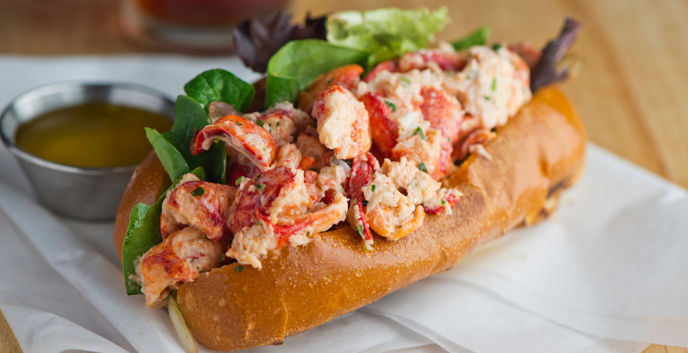 A lobster roll on a plate close up with butter