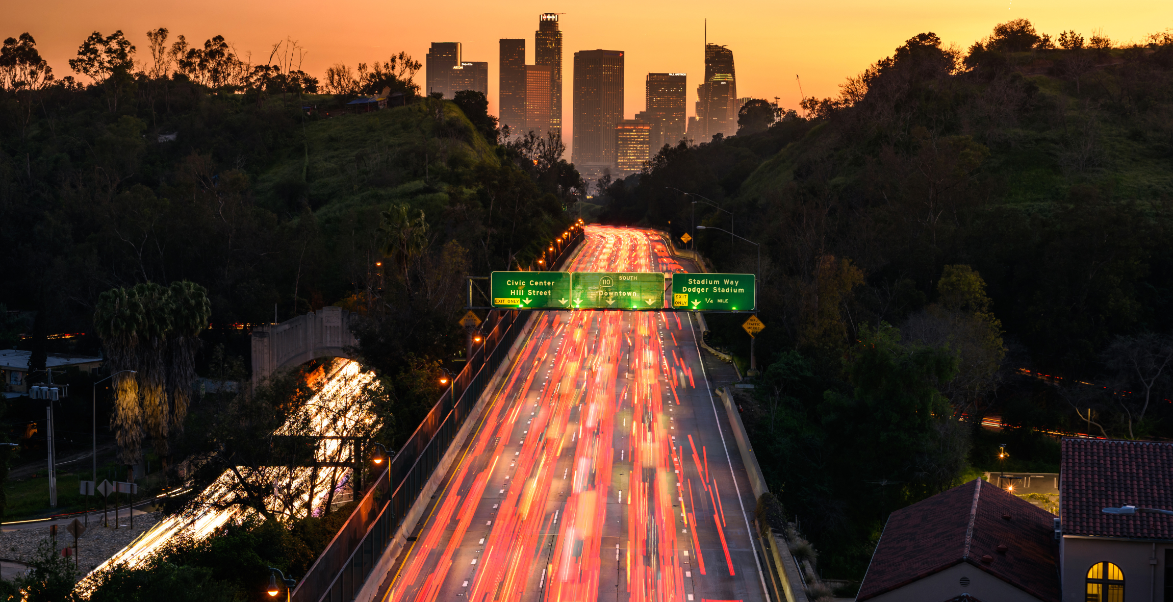 Aerial view of Los Angeles freeway with a sunset in the background.