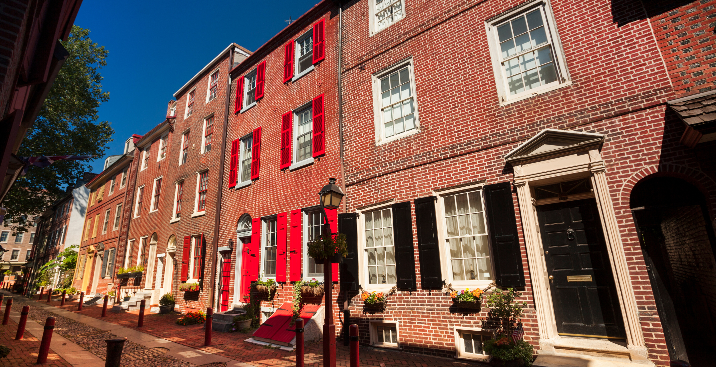 A row of red brick houses in front of a blue sky